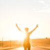 person raising both hands doing peace sign hand gesture on road during daytime